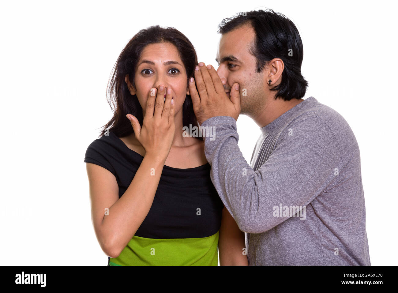 Studio shot der Persischen Paar mit Mann flüsternd zu Frau looki Stockfoto