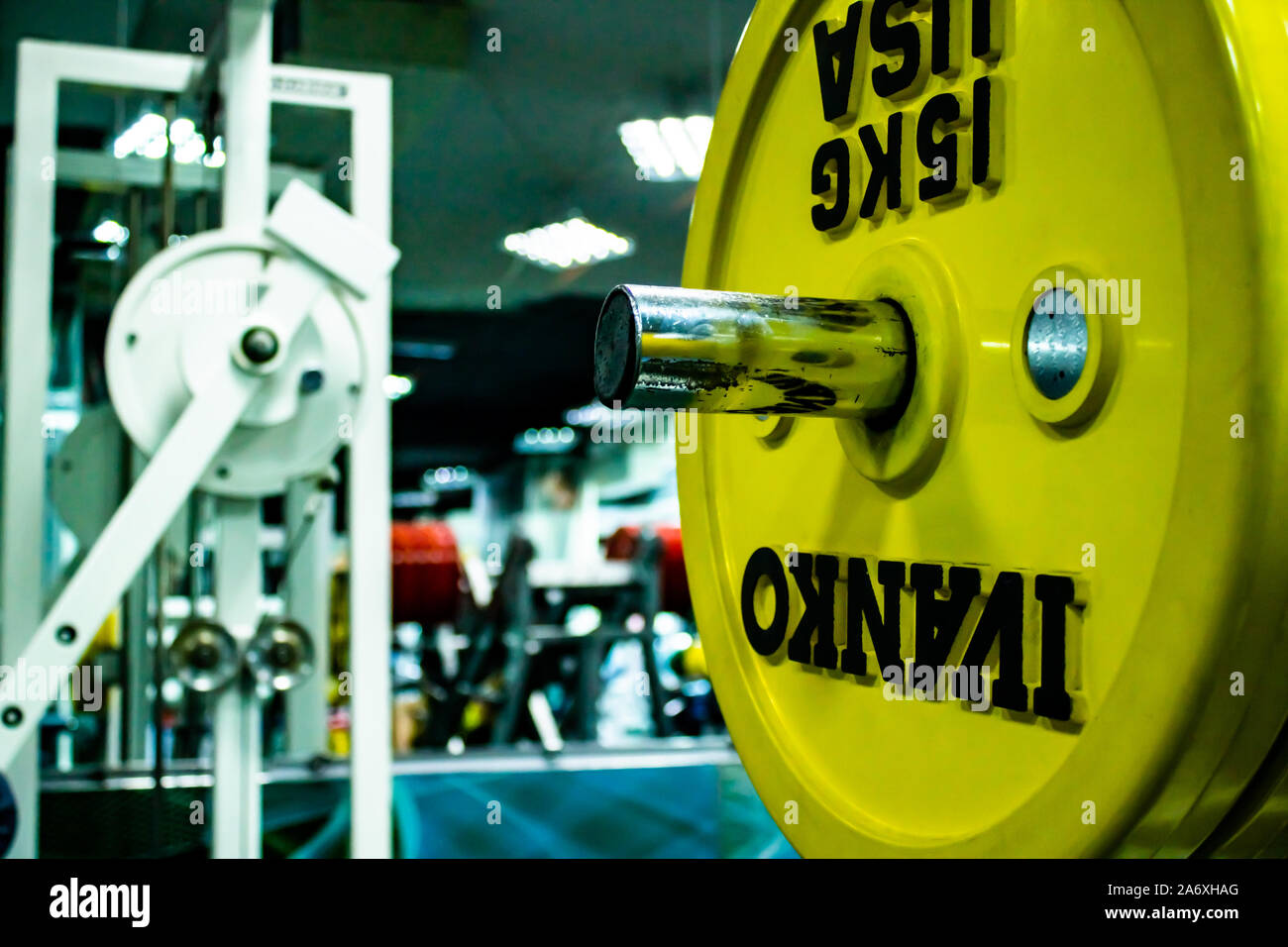Professionelle yellow Hanteln und Hantelscheiben auf dem Hintergrund einer Fitness Gym. Sport Equipment. Stockfoto