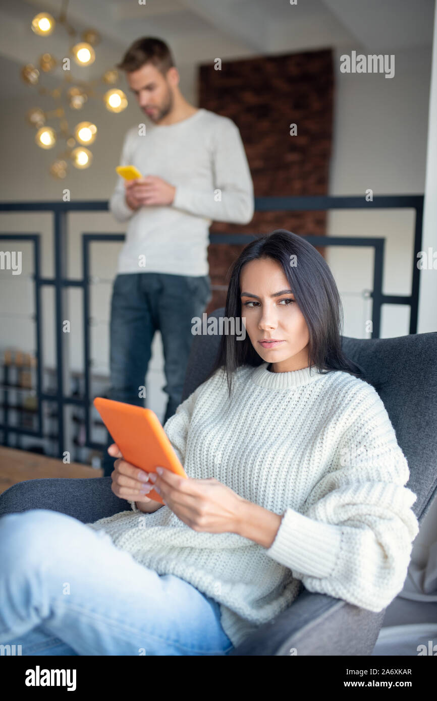 Frau tragen Pullover im Wohnzimmer sitzen Stockfoto