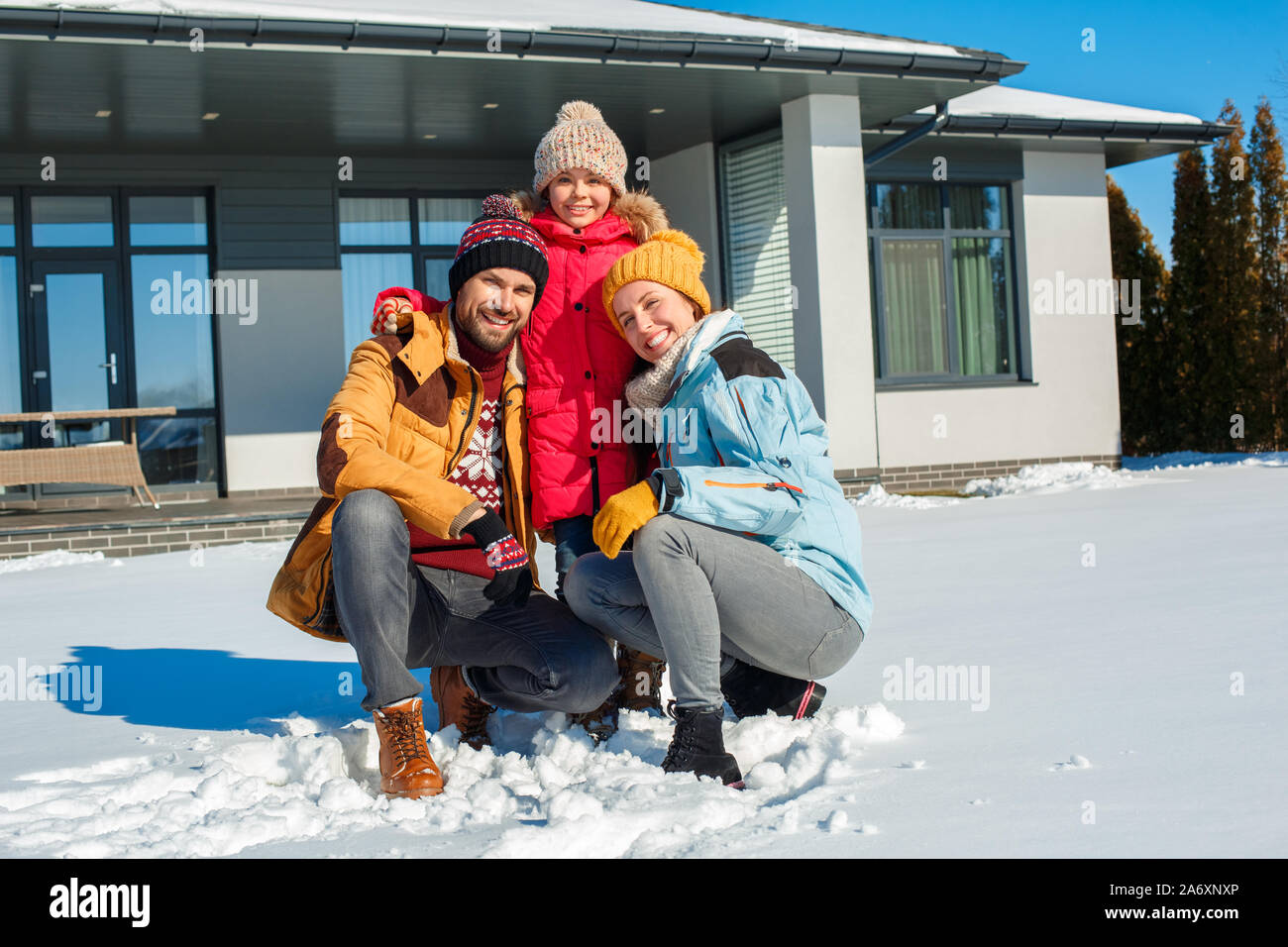 Winter Urlaub. Zeit mit der Familie zusammen im Freien in der Nähe von Haus fröhlich lächelnd umarmen Stockfoto