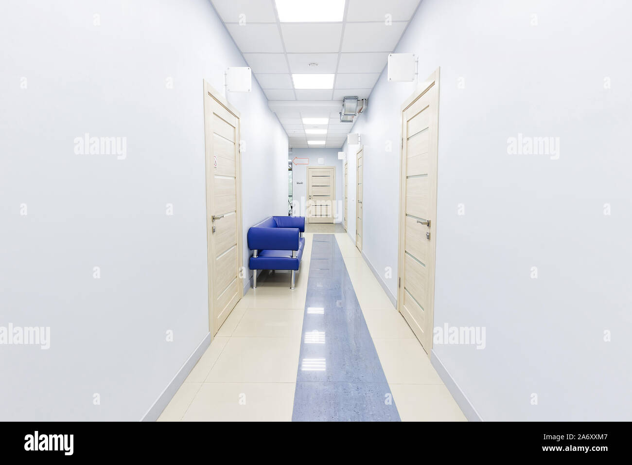 Innenraum der Medizinischen Klinik helle Flur mit blauen Stühlen. Stockfoto