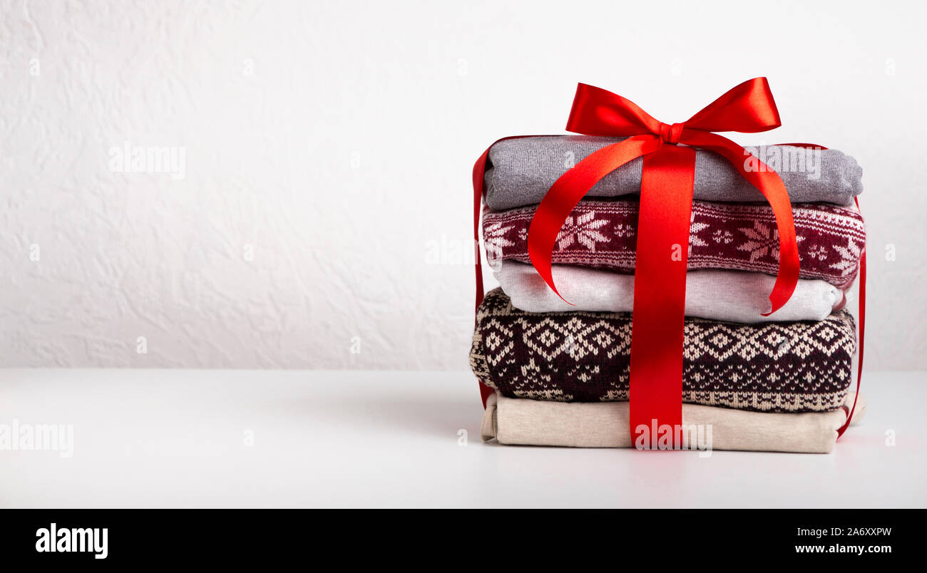 Stapel Pullover von Red Ribbon gewickelt mit Bogen auf Weiß Stockfoto
