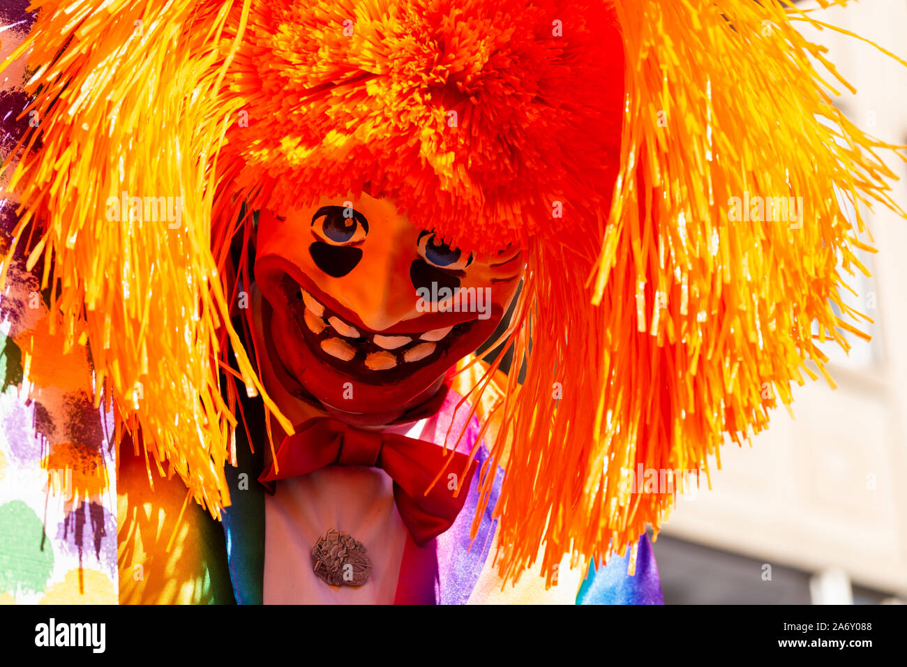 Marktplatz, Basel, Schweiz - März 13., 2019. Nahaufnahme einer Karneval Teilnehmer in einem bunten Kostüm mit orange Haare Stockfoto