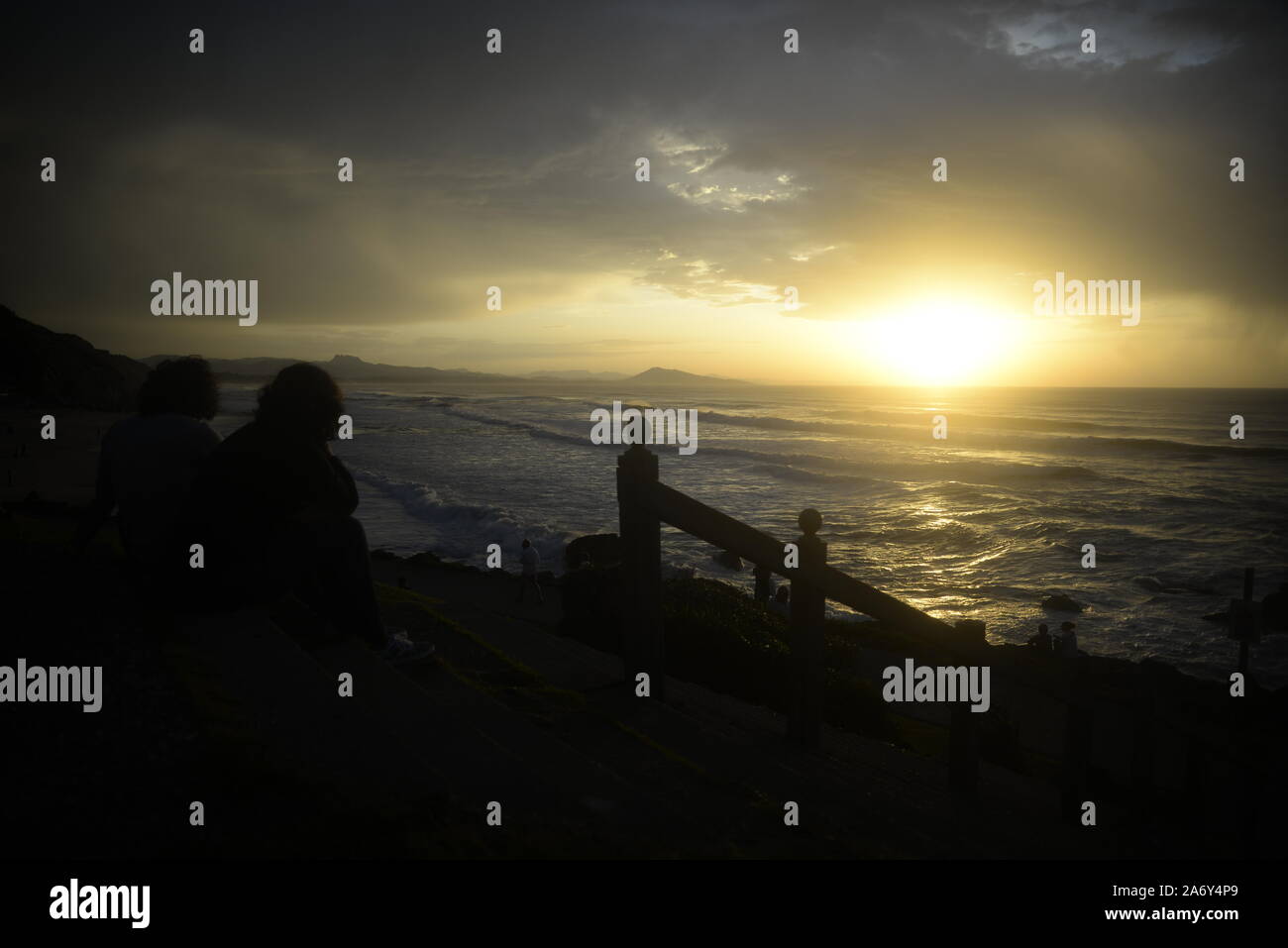 Paar mit Blick auf das Meer bei Sonnenuntergang im Südwesten Frankreichs, pasakdek Stockfoto