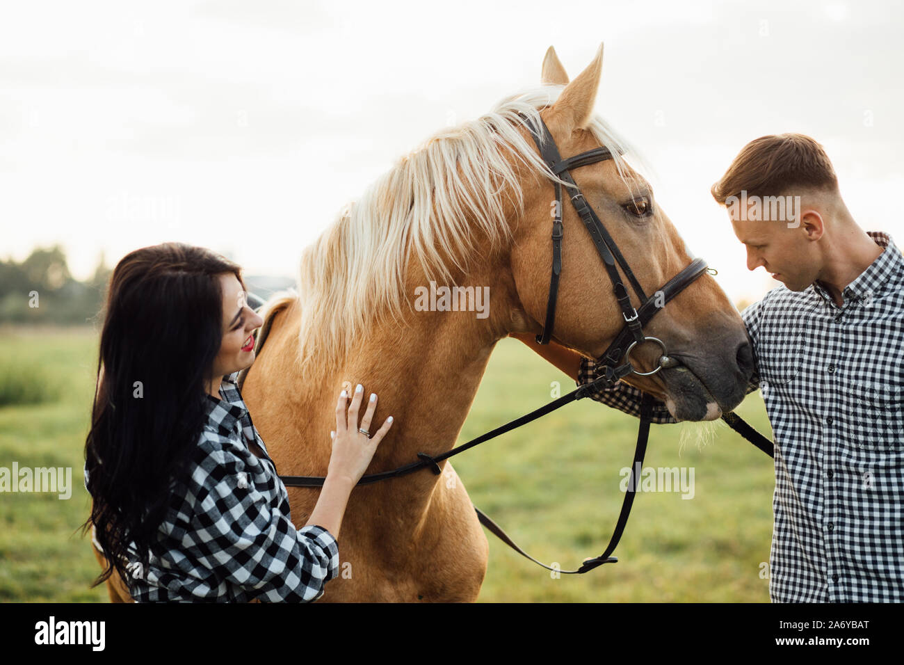Glücklich liebend Paar verbringt Zeit mit Pferden auf der Ranch Stockfoto