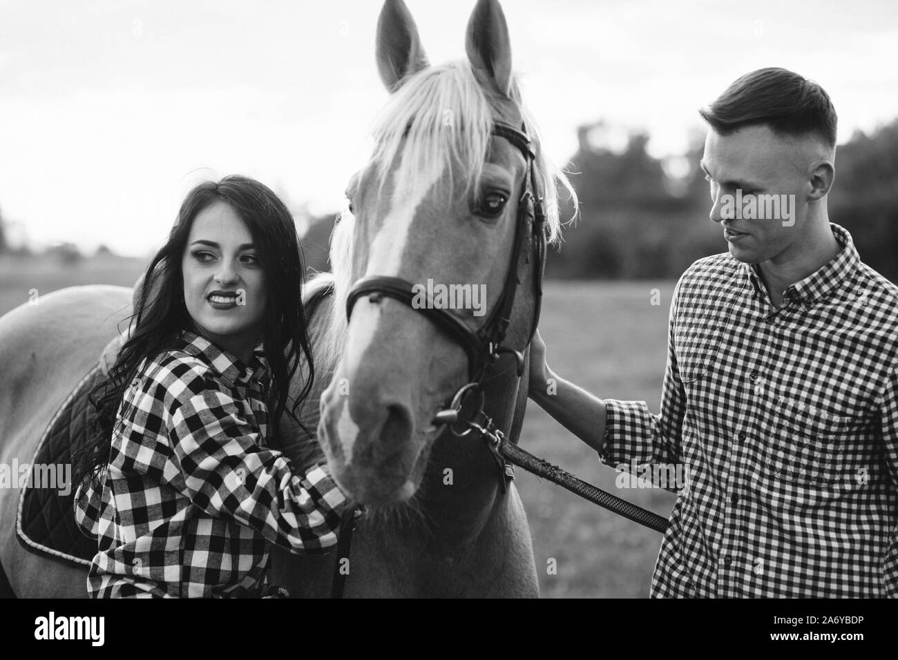 Glücklich liebend Paar verbringt Zeit mit Pferden auf der Ranch Stockfoto