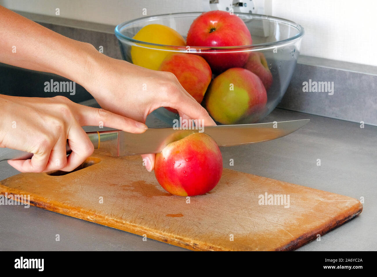 Kochen Konzept. Äpfel in Scheiben schneiden ist auf Holzbrett am Küchentisch. Stockfoto