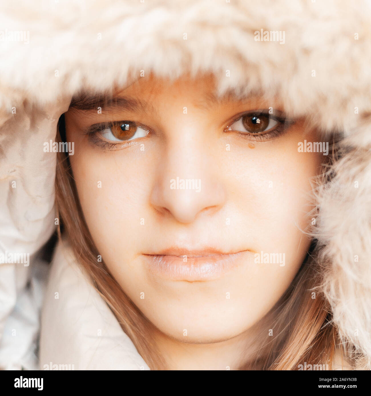 Junges Mädchen mit braunen Augen tragen Winter Mantel mit Kapuze auf, Kopf schoss. lässig, jeden Tag tragen. Stockfoto
