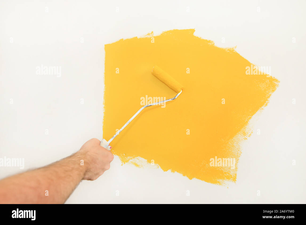 Bauarbeiter und Handwerker tun beenden Renovierung im Apartment. Maler mit paint Bürstenrolle Anstrich der Wand mit der Farbe gelb. Stockfoto