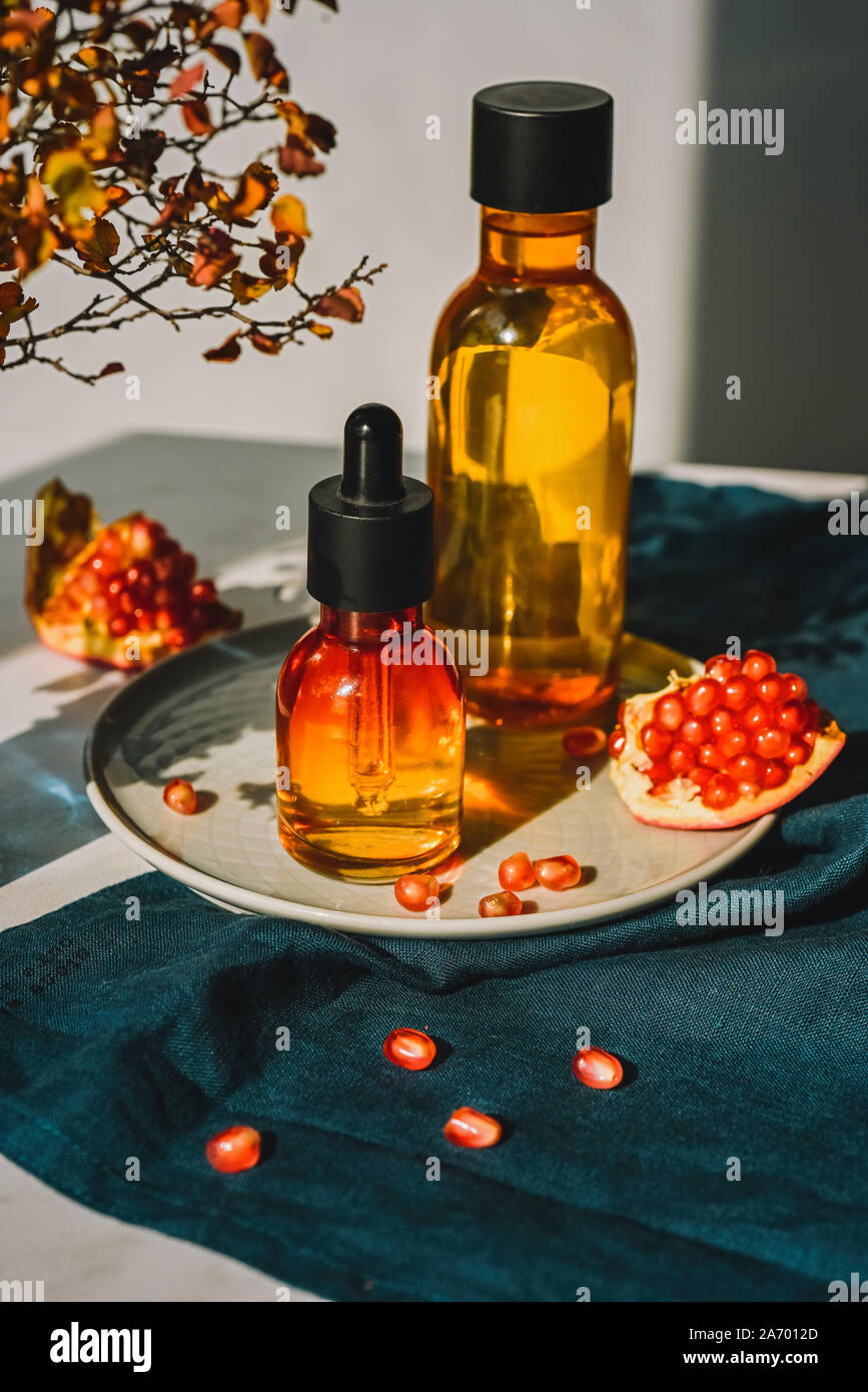 Granatapfel Kernöl, Molke in verschiedenen Flaschen auf eine dekorative Reibe. Lifestyle. Konzept der Anti-aging Bio care Stockfoto