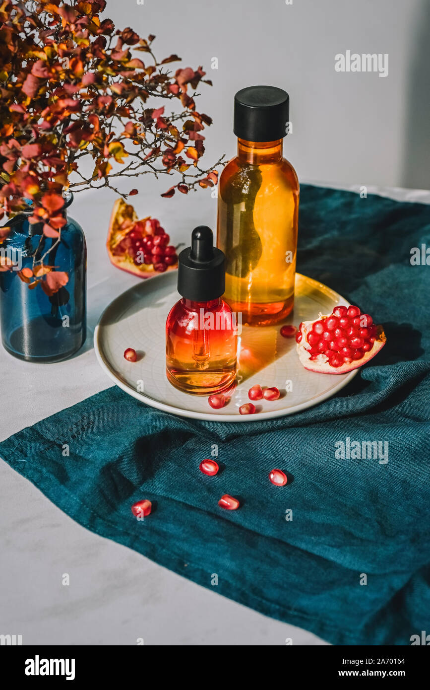 Granatapfel Kernöl, Molke in verschiedenen Flaschen auf eine dekorative Reibe. Lifestyle. Konzept der Anti-aging Bio care Stockfoto