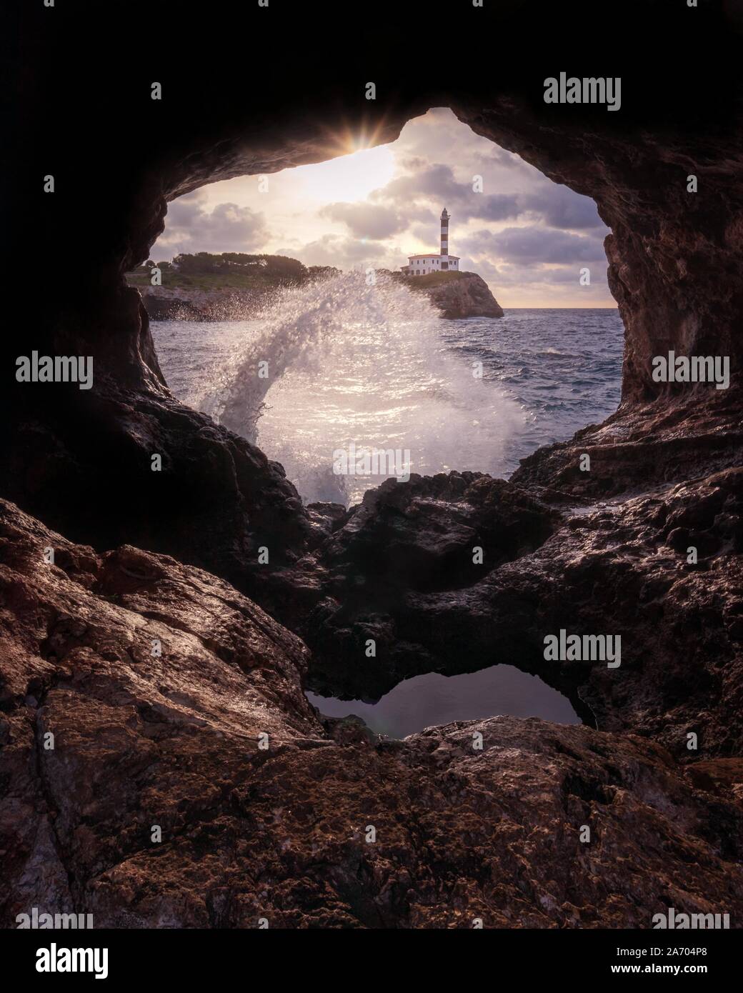 Portocolom Leuchtturm, natürliche Höhle, blaues Meer withwave und Sea Spray, Mallorca, Balearen, Spanien. Stockfoto