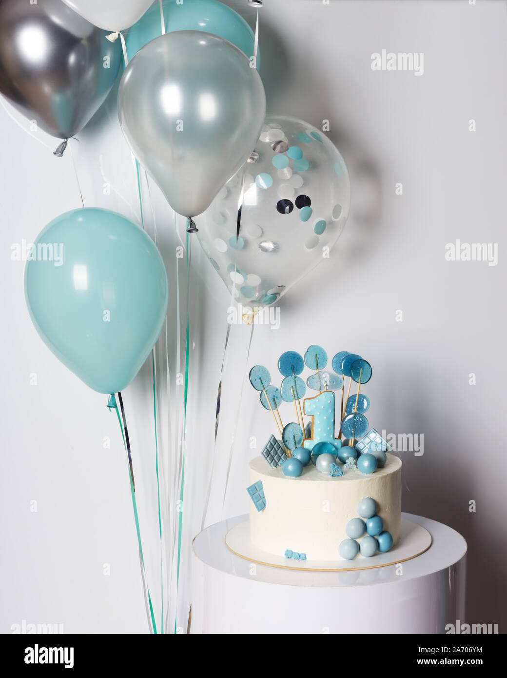 Weiß und Blau Kuchen mit Süßigkeiten und Cookie Nummer eins auf junge ersten Geburtstag. Ballons und Konfetti auf Hintergrund Stockfoto