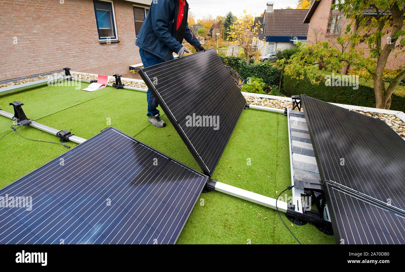 Ein Arbeitnehmer ist die Installation von Solarzellen auf einem flachen Dach in den Niederlanden Stockfoto