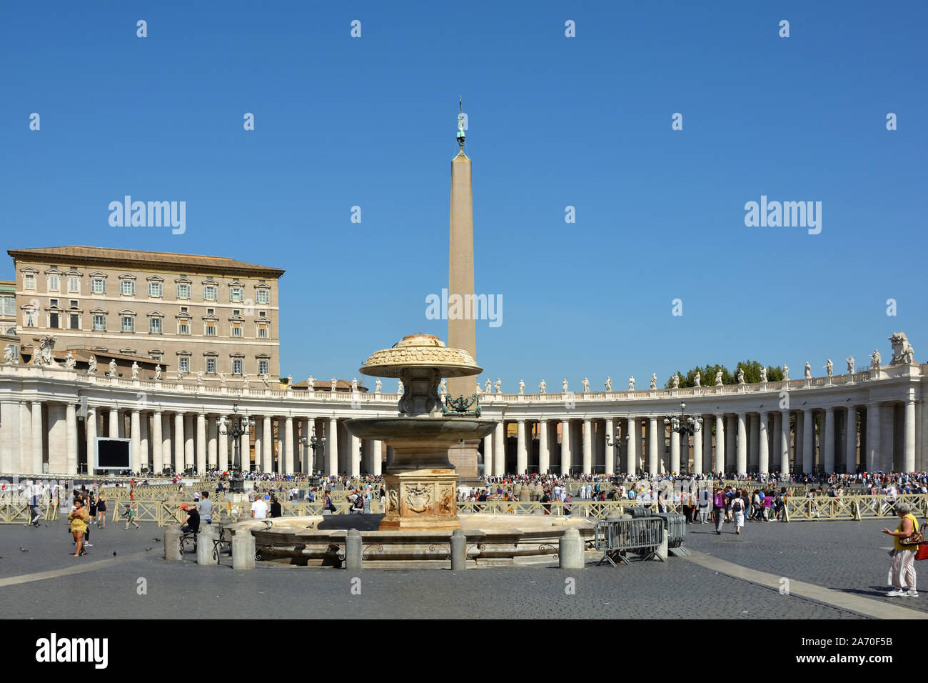 Touristen auf dem Saint Peters Platz mit Blick auf den Apostolischen Palast und Fontana del Bernini in der Vatikanstadt in Rom - Italien. Stockfoto
