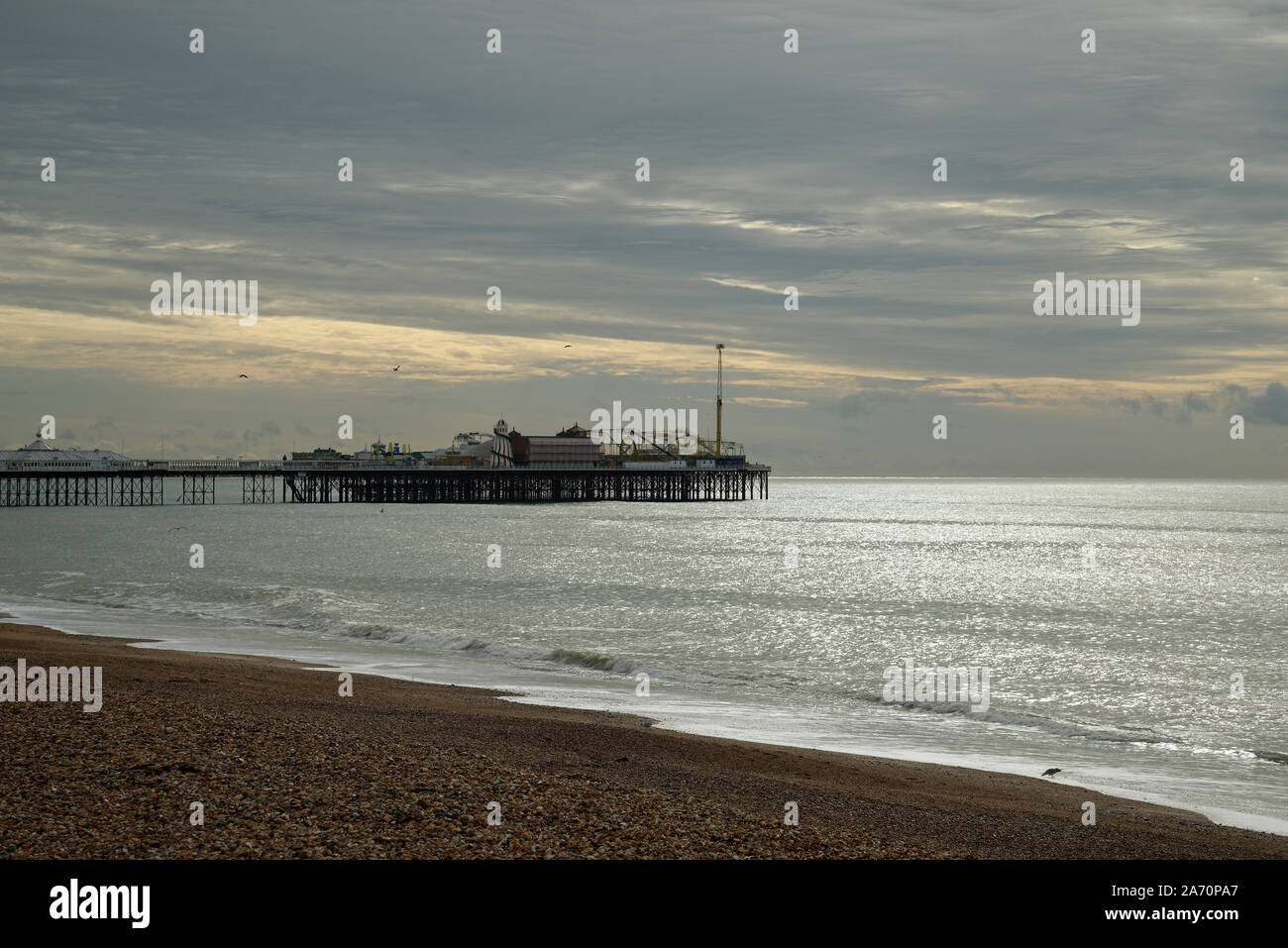 Brighton Beach und Pier im Hintergrund. Am frühen Morgen, mit der aufgehenden Sonne im Osten. Stockfoto