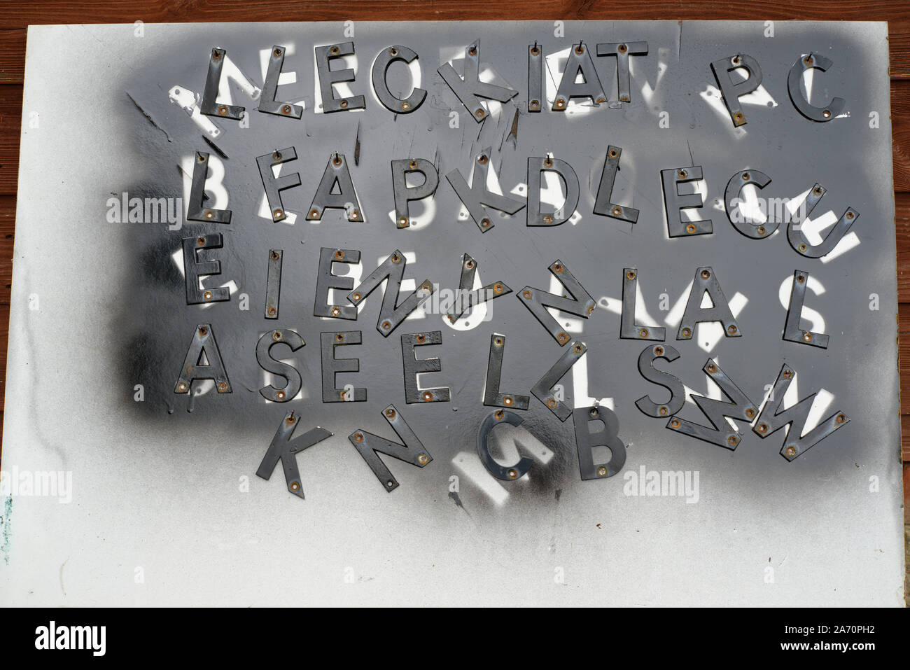 Spritzlackiert schwarzen Buchstaben und die Vorlage nach der Malerei. Eine typografische Gestaltung Rechtschreibung keine Worte. Briefe hing an Nägel lackiert werden. Stockfoto