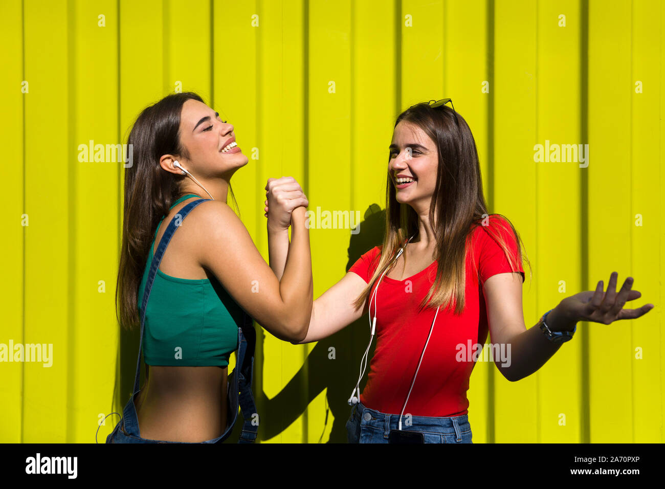 Bild von zwei jungen Frauen, die Freunde stehen gerne im Freien über gelbe Wand Stockfoto