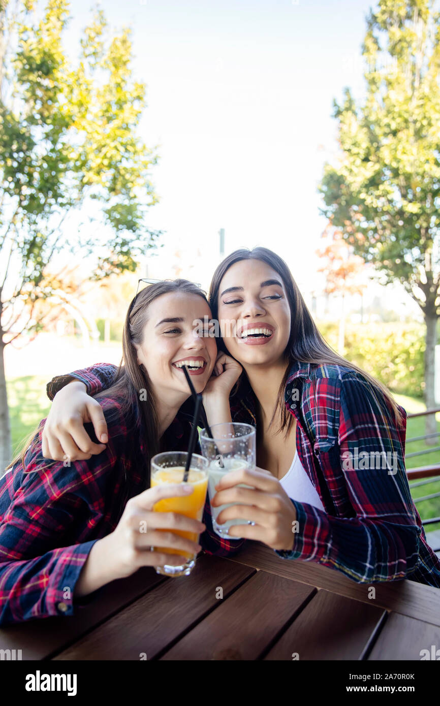 Zwei junge Frauen trinken Saft und Limonade in den Park an einem sonnigen Tag Stockfoto