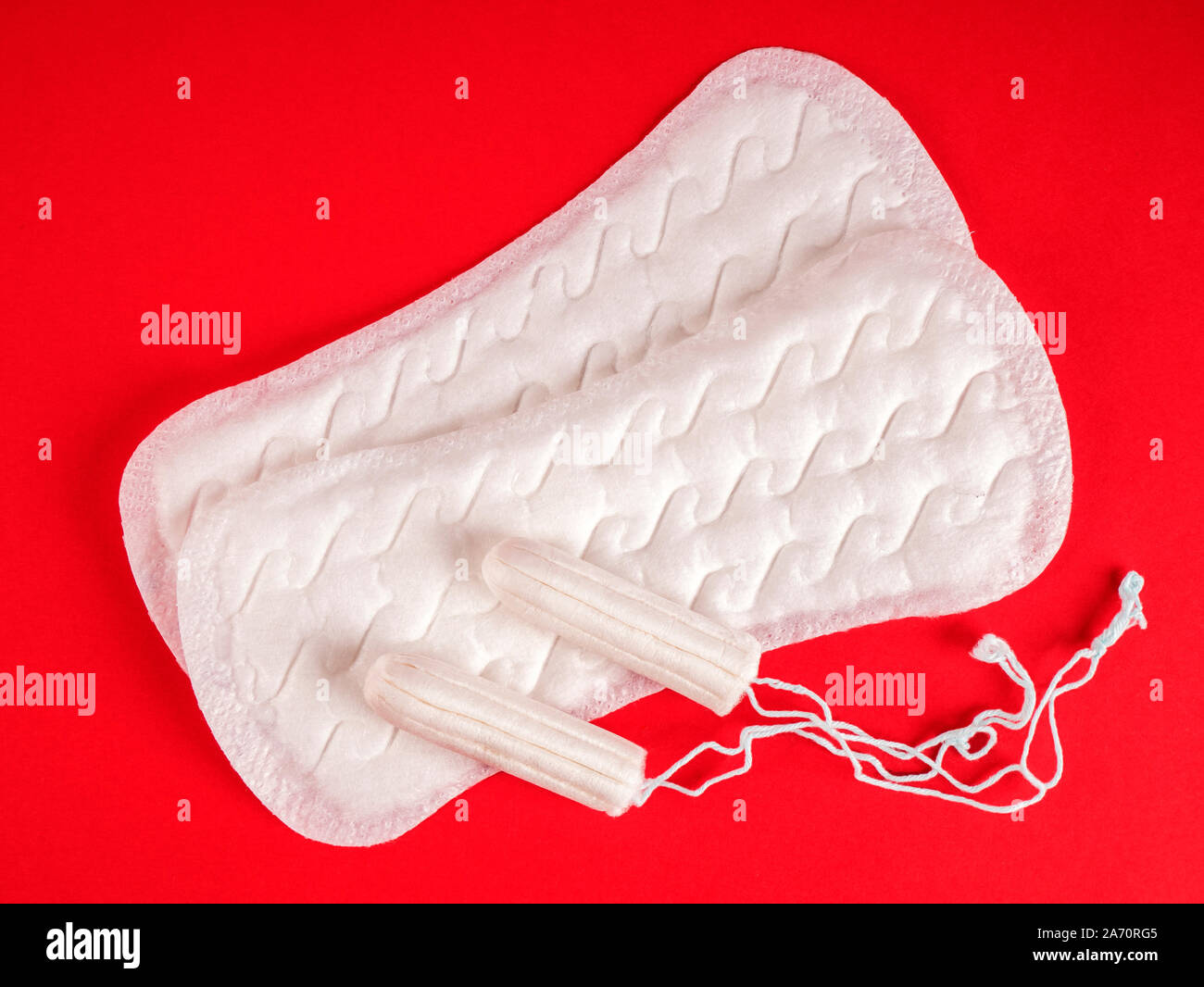 Die Menstruation. Damenbinden und Tampons auf rotem Hintergrund Stockfoto
