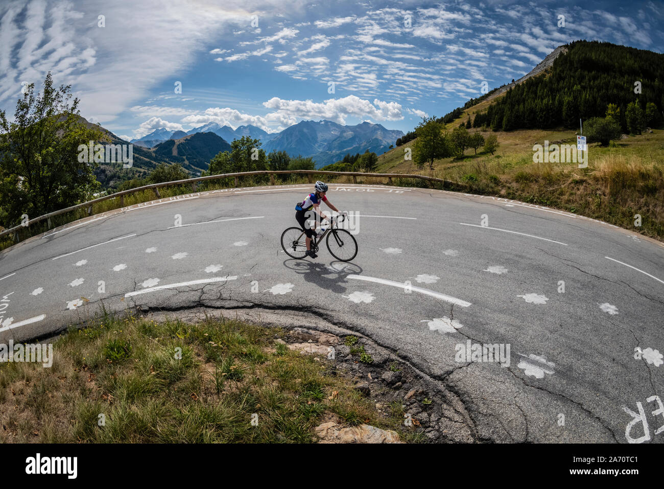 Reife weibliche Radfahrer reiten durch 3 auf dem klassischen Klettern in Alpe d'Huez, Französische Alpen biegen. Stockfoto