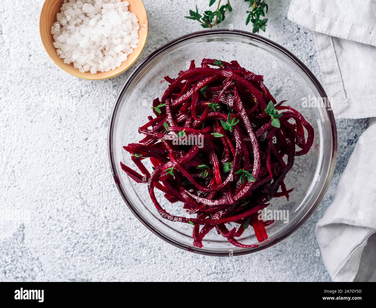 Rohe rote Beete nudeln Salat. Gemüse Nudeln - spaghetti Zuckerrüben auf grauem Zement Hintergrund. Kopieren Sie Platz für Text. Ideen und Rezept für Sauber Essen, Raw vegetarisches Essen Konzept. Top View oder flach. Stockfoto