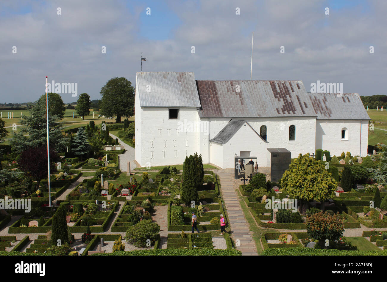 JELLING, Dänemark, 15. JULI 2019: Außenansicht der Kirche von Jelling und der umliegende Friedhof und Runensteine. Die Kirche ist auf der UNESCO-Liste Stockfoto