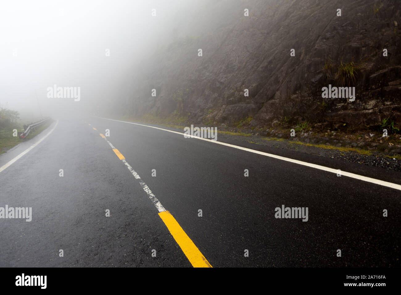 Foggy Road mit gelben Markierungen Stockfoto