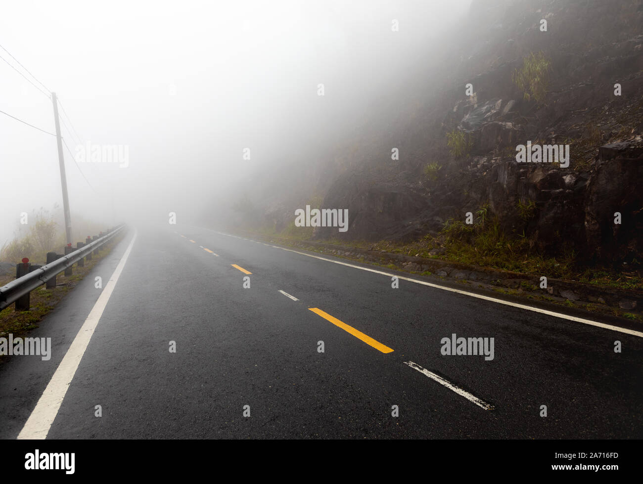 Foggy Road mit gelben Markierungen Stockfoto