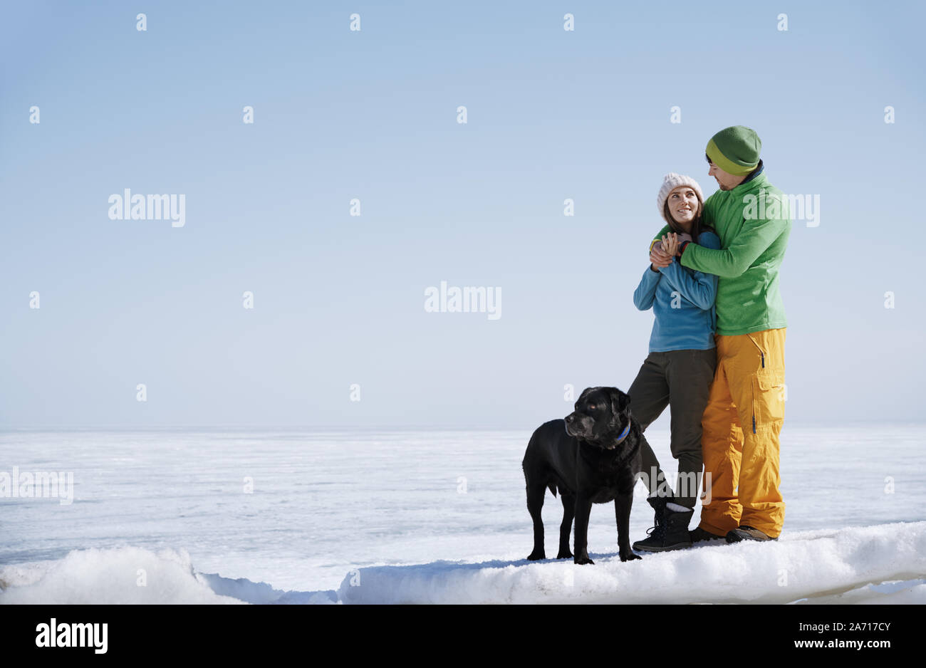 Junge erwachsene Paare im Freien mit Hund Spaß im Winter Landschaft Stockfoto