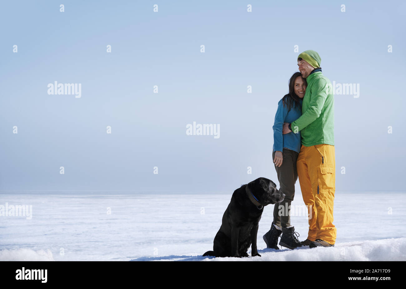 Junge erwachsene Paare im Freien mit Hund Spaß im Winter Landschaft Stockfoto