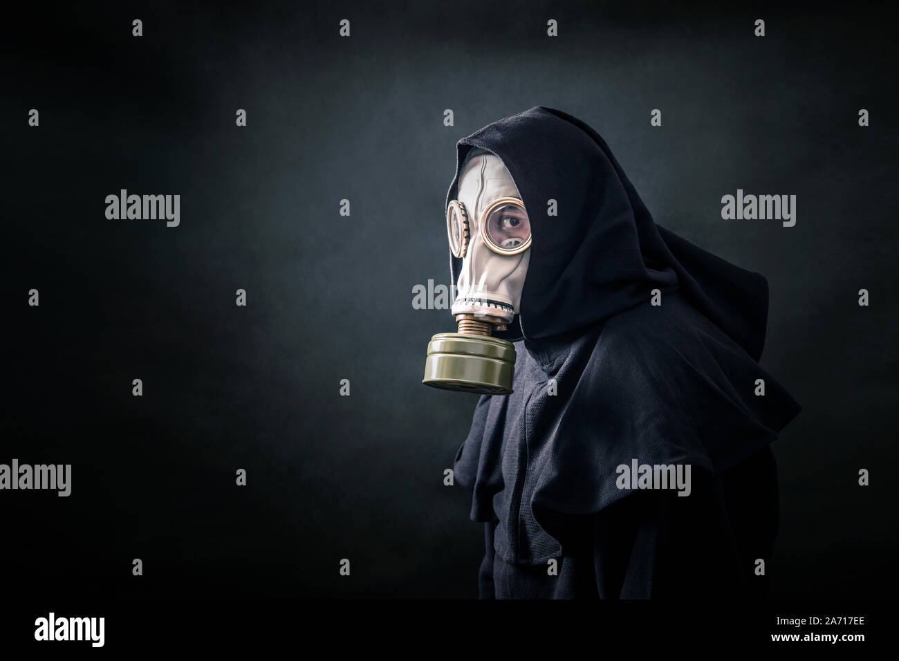 Mann in einem Gas Maske und Umhang mit Kapuze. Umwelt Umweltverschmutzung. Stockfoto