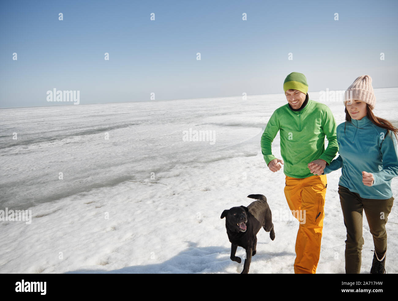 Junge erwachsene Paare im Freien mit Hund Spaß im Winter Landschaft Stockfoto