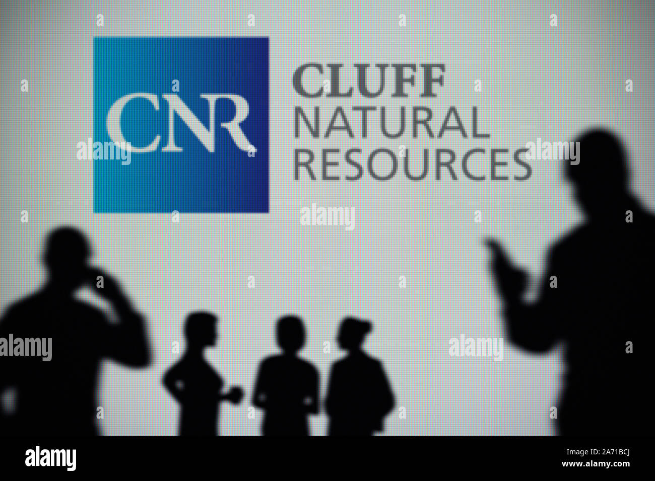 Die cluff natürlichen Ressourcen Logo ist auf einen LED-Bildschirm im Hintergrund, während eine Silhouette Person ein Smartphone verwendet (nur redaktionelle Nutzung) Stockfoto