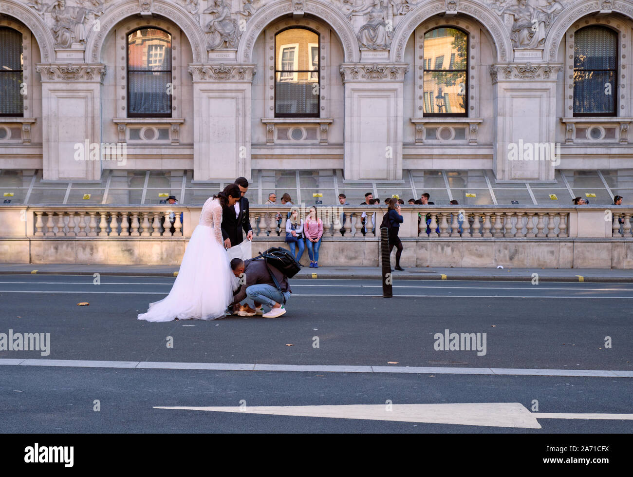 Fotograf einrichten Paar für Hochzeit Bild schiessen in der Mitte der Straße in London. Stockfoto