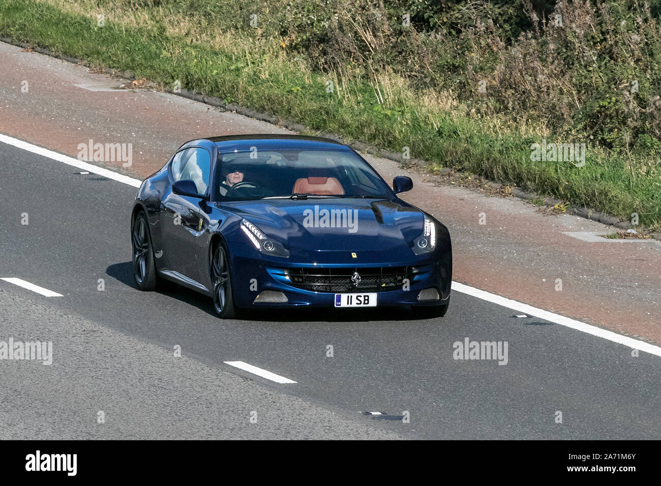 2013 blue Ferrari FF V12 Roadster; Fahrt auf der Autobahn M6 in der Nähe von Preston in Lancashire, Großbritannien Stockfoto