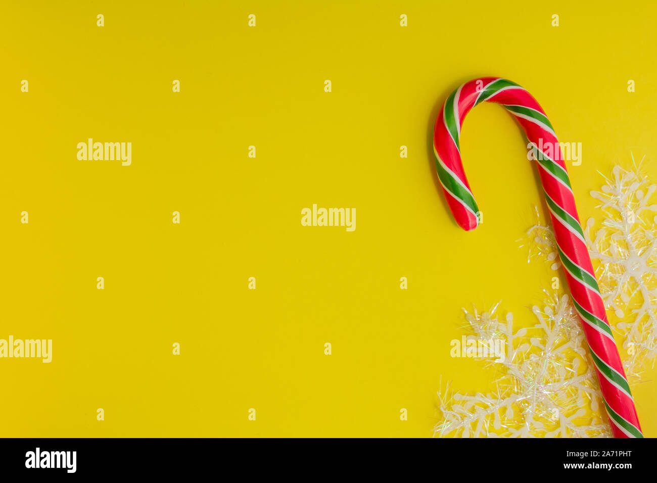 Traditionelle Weihnachten caramel Candy Cane und Schneeflocken auf gelbem Hintergrund. Winterurlaub festliche Grußkarte mit Platz für den Text kopieren Stockfoto