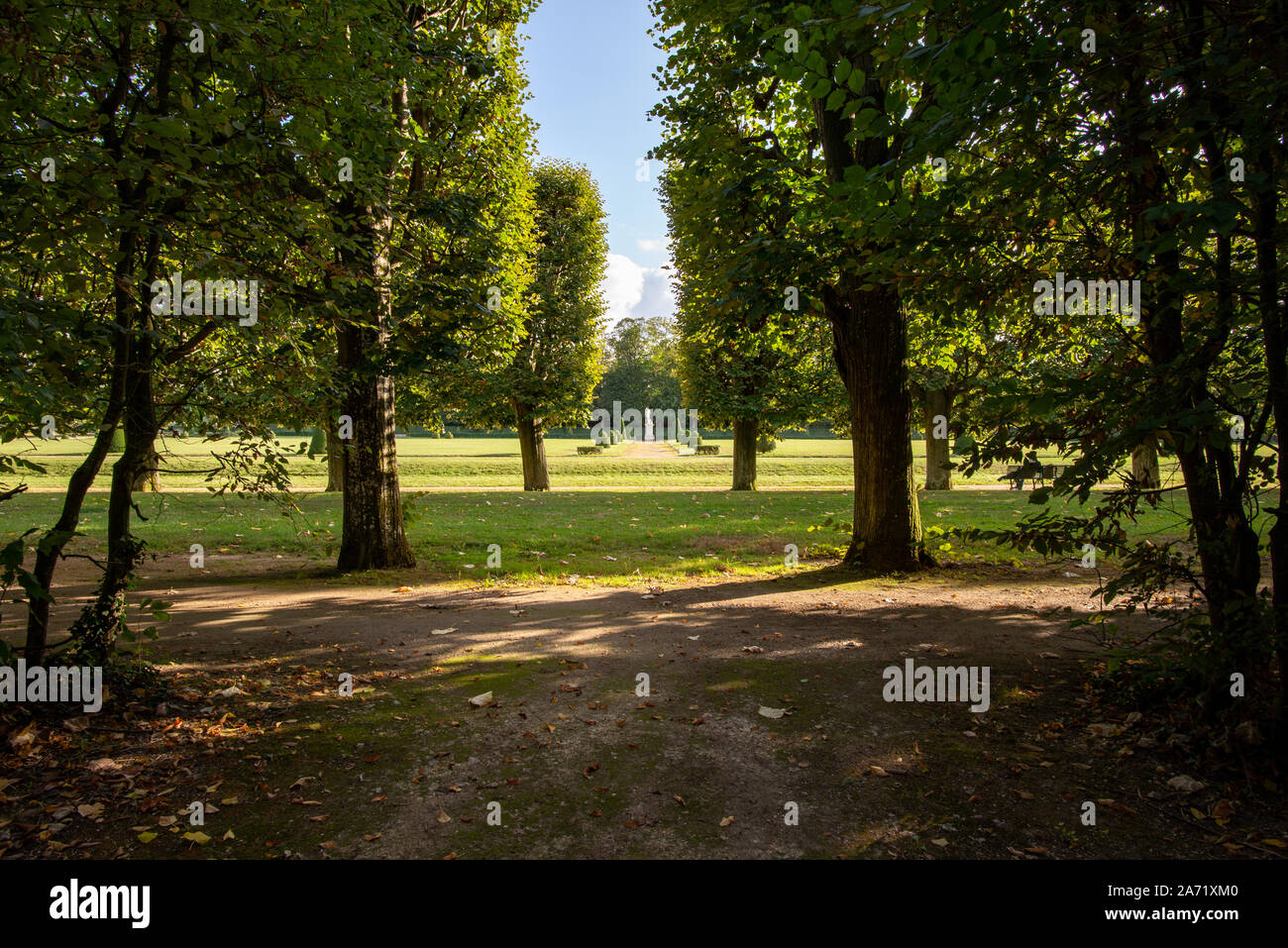 Champs-sur-Marne, Frankreich - Oktober 6, 2019: Geradlinige garten Gasse mit Linden bilden gerade Kanten und eine Apollo Statue in der Mitte, nehmen Stockfoto