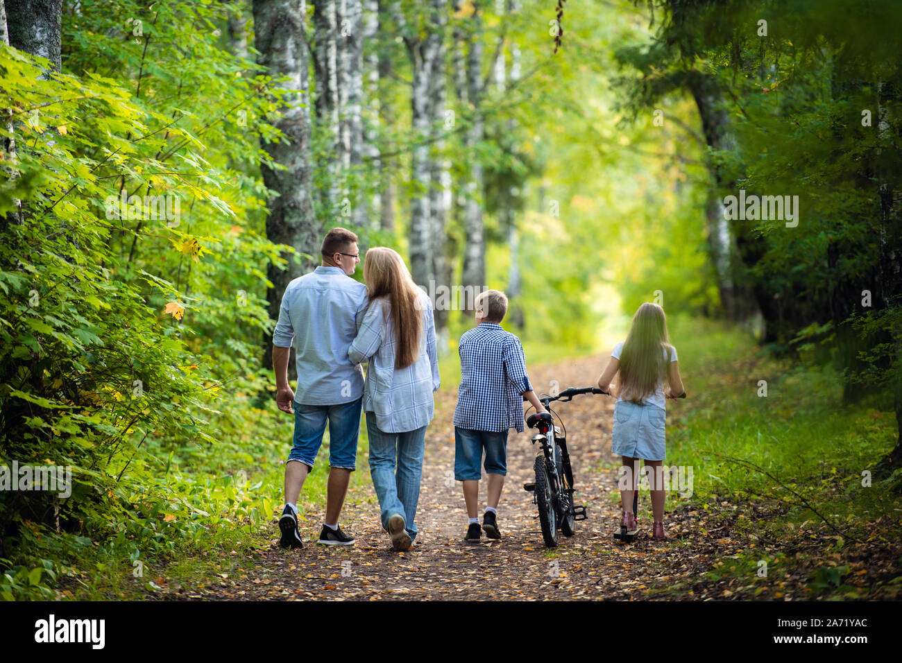 Rückansicht - eine Familie mit zwei Kindern Spaziergänge im Park Stockfoto