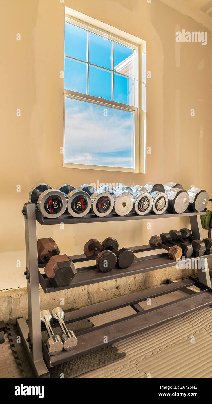 Vertikale Auswahl an freien Gewichten für Gewichtheben in einer Garage. Stockfoto