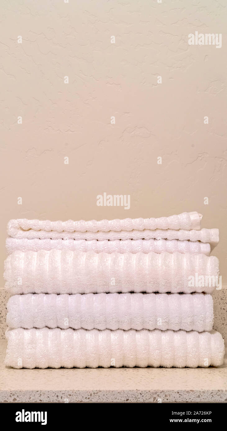 Vertikale Stapelrahmen der sauberen weißen gerippten Handtücher im Badezimmer Stockfoto
