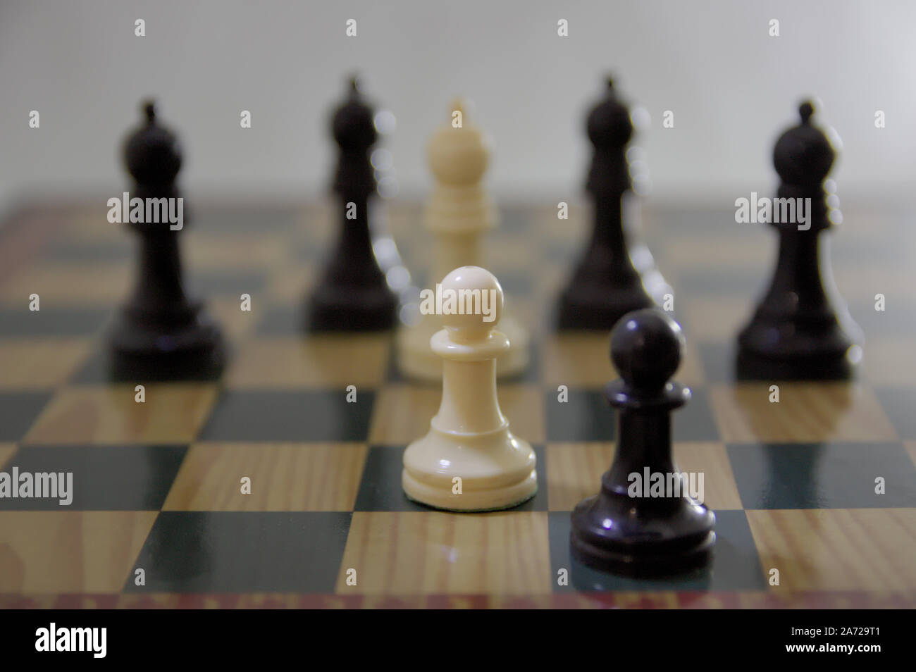 Konzept der Chase auf dem Schachbrett. Zwei schwarze und weiße Schachfiguren sind durch 5 Bischöfe auf dem Board gestoppt Stockfoto