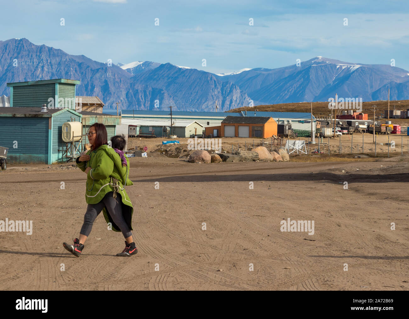 Eskimo - Inuit Frau, die ihr Baby auf dem Rücken in Pond Inlet, Baffin Island, Kanada. Stockfoto