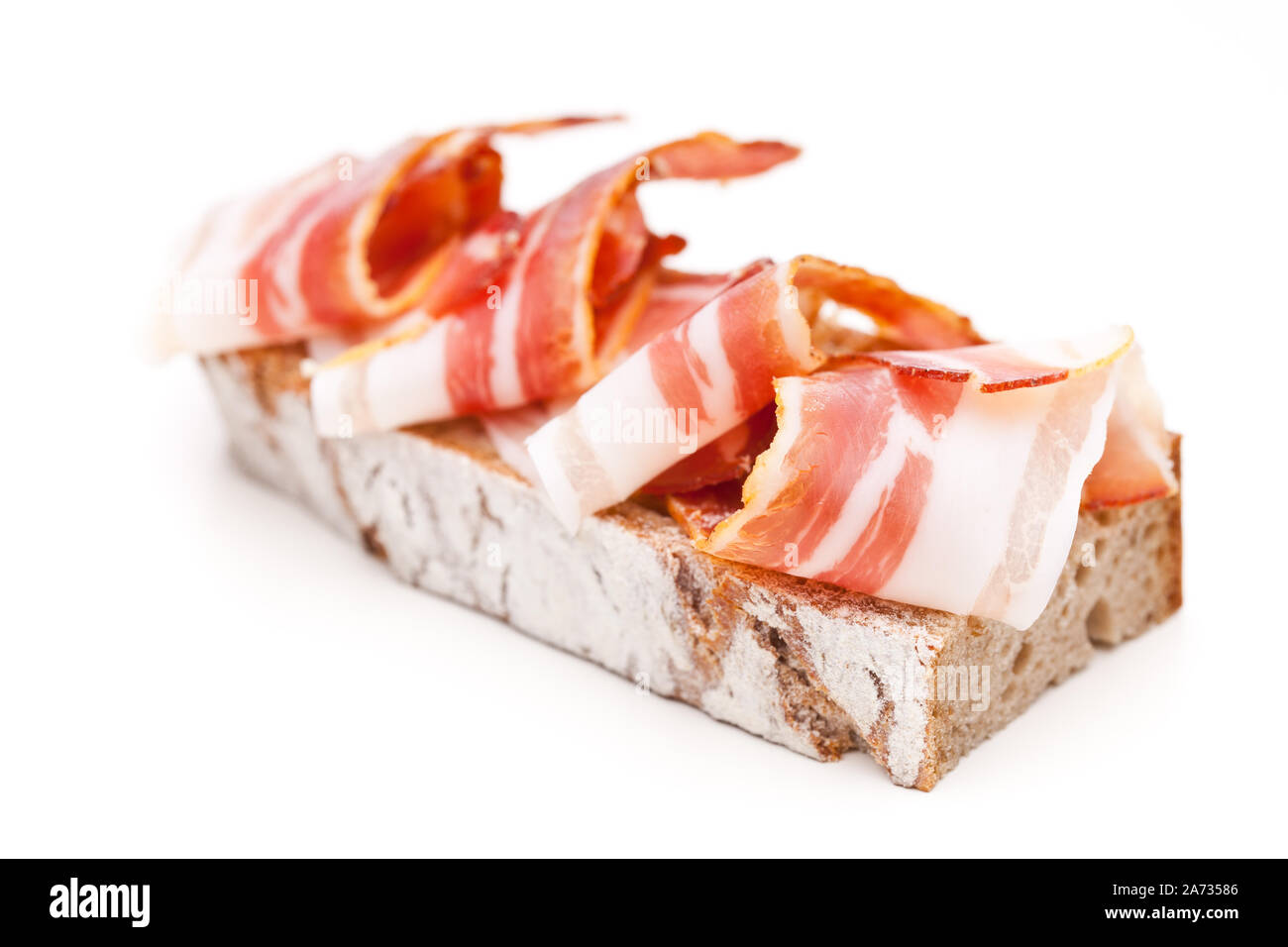 Ein Brot mit Speck auf weißem Hintergrund Stockfoto