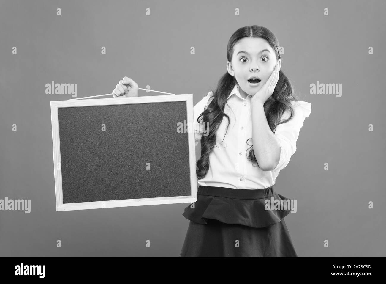 Oh mein Gott. Überrascht Schüler in Schuluniform. kopieren. Kommerzielle Vermarktung conept. Business School Anzeige. Neue shopping Idee. Schule Market Sales. Beschilderung. Überrascht schule mädchen mit blackboard. Stockfoto