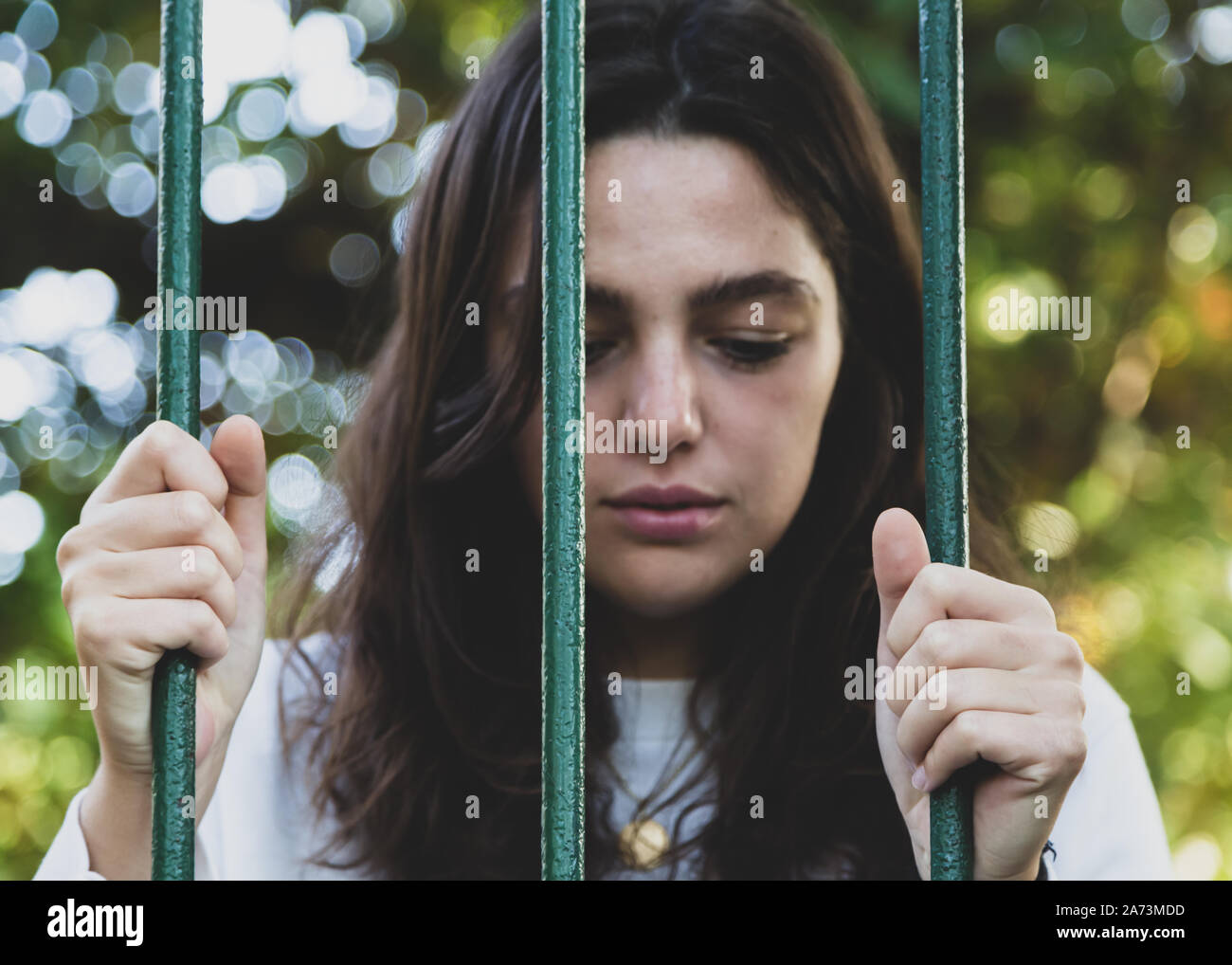 Traurige Frau hinter Gittern Stockfoto