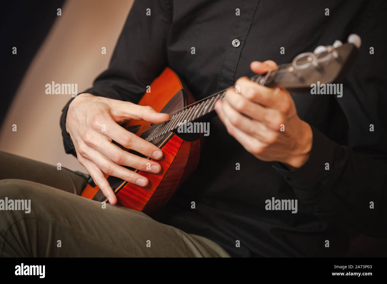 Ein Mann spielt Balalaika, Nahaufnahme mit weichen selektiven Fokus auf Händen Stockfoto