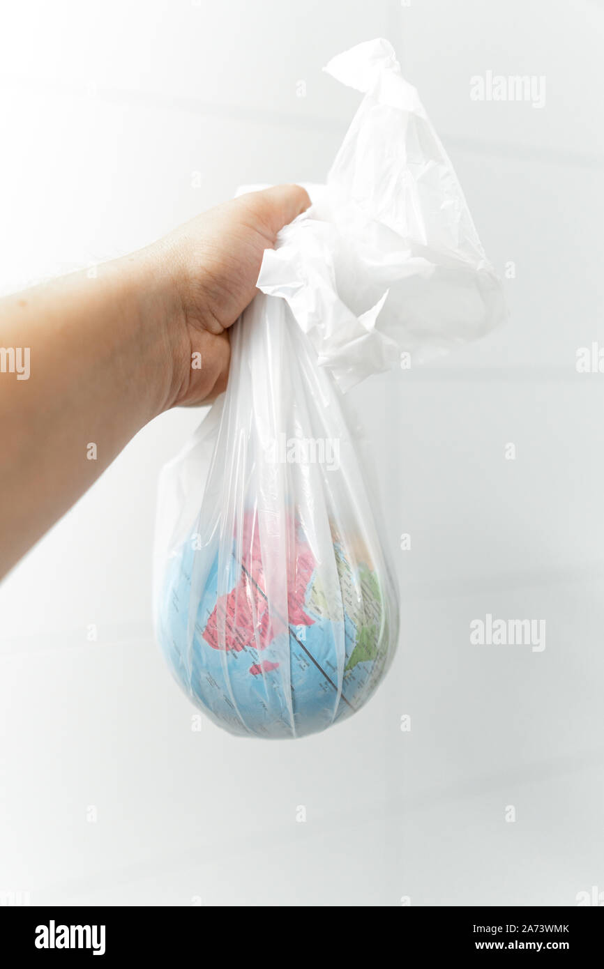 Der Mensch hält die Erde in Plastik gewickelt. Hintergrund weiß Stockfoto