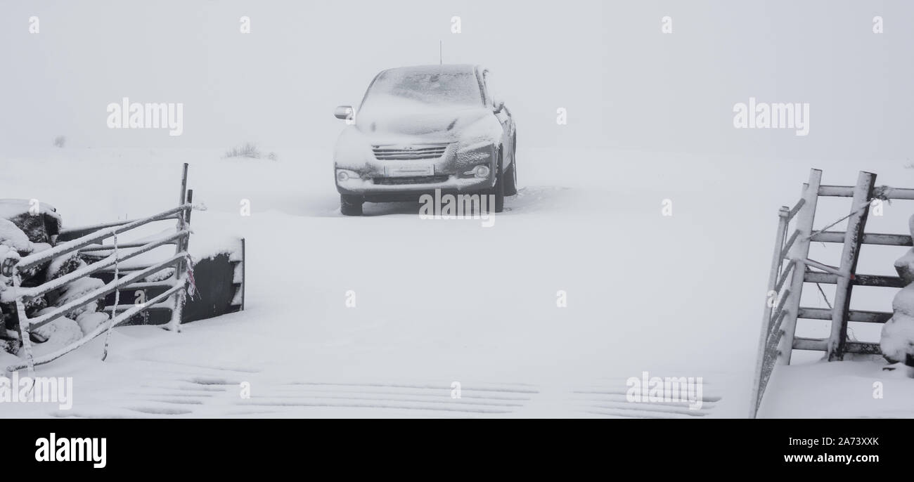 Ein kalter Wintertag. Ein Auto ist in einem Feld und nach dem Schnee fallen Sie durch Drifts umgeben wird geparkt. Der Blick durch die Farm Tore über einen Vieh Raster Stockfoto