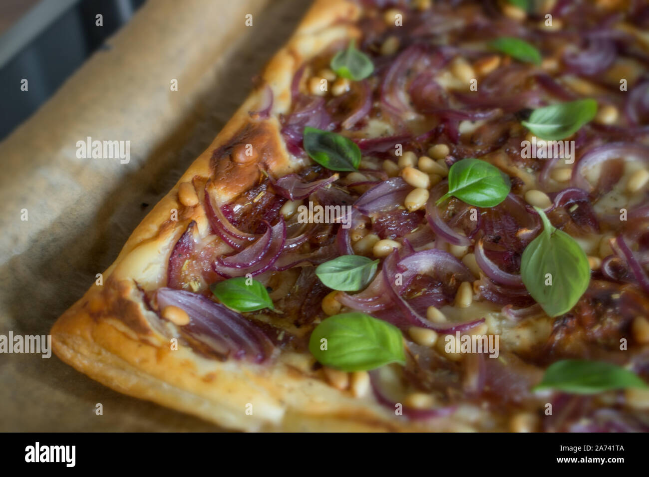 Essen Fotografie Blätterteig mit Roten Zwiebeln, Balsamico Essig Reduktion und Pinienkernen Stockfoto